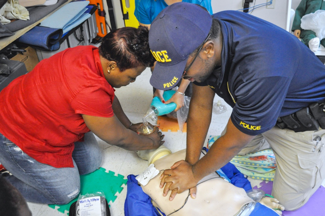 VIPD officers Charmayne Thomas and Clint Ettinoffe practice life-saving procedures on a CPR training dummy.