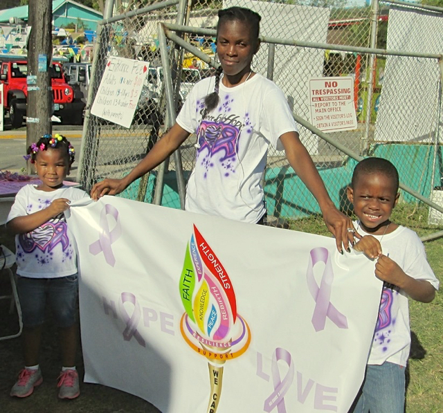 Ohanna Mitchell, 4, Onnika Gumbs, and KeMoy Joshua, 4, hold up their banner.