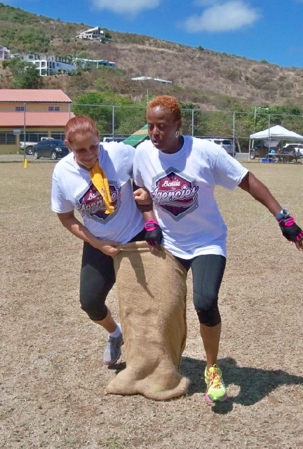 Lynette Sierra and Monique Simon, both from WAPA, run a sack race. 