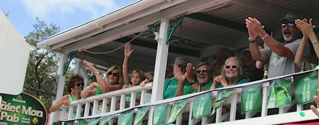 Revelers enjoy the parade from the Quiet Mon Pub.