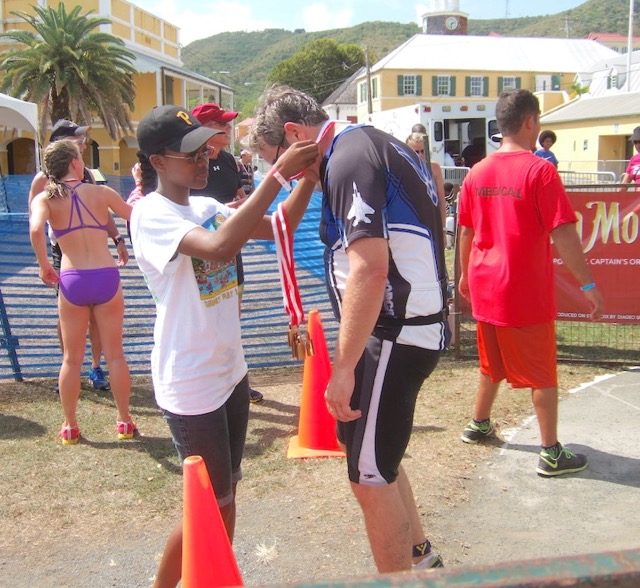 A competitor receives a medal after finishing the grueling triathlon.
