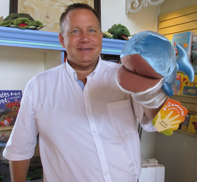 Store manager Greg Gunderson plays with a puppet.