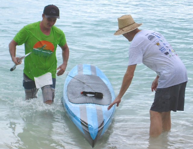 Casey Levin, winner in the open course, is helped out of the water by V.I. National Park Superintendent Brion FitzGerald.