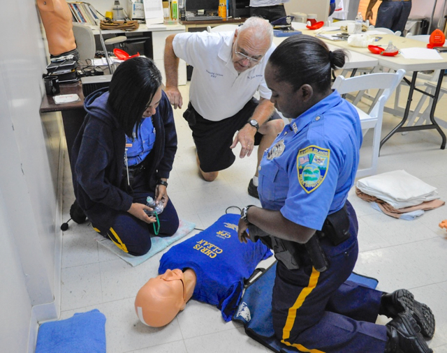 EMT Bob Malacarne explains CPR techniques to VIPD officers Yaniris Madera and Shennel Weekes.