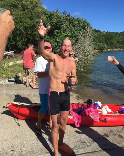 Friends toast Jeff Miller after he completes his swim around St. John.
