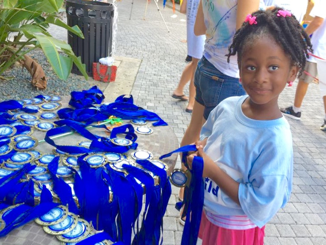 Six-year-old Lamy'r Perez, who received her wish earlier this year, helped organizers hand out medals at Saturday's event. 