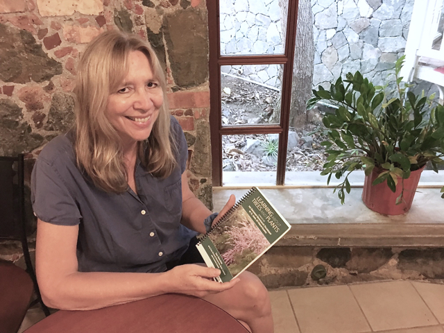 Gail Karlsson holds a copy of 'Learning about Trees and Plants.'