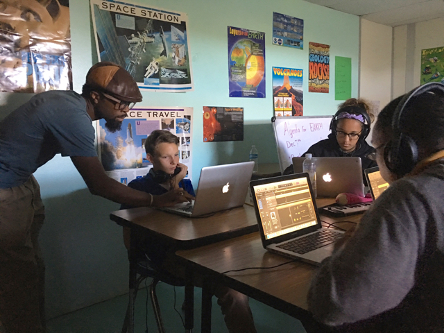 Dennison Blackett helps a classroom of students lay down a beat.