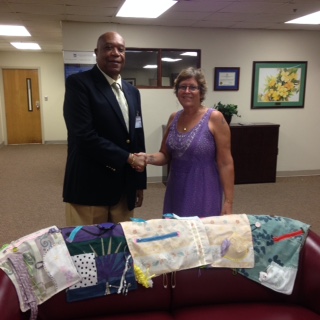 SRMC CEO Dr. Bernard Wheatley receives fidget quilts from Cheryl Esquilin. 
