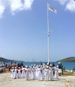 The Ulla F. Muller Bamboula Dancers watch as the V.I. flag is lowered during African Liberation Day opening ceremonies. It was replaced for the day by the Pan African flag. (Photo by Augustine Holder)