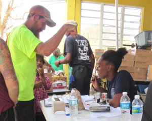 A member of the V.I. Fire Service assists a St. John resident with emergency rations at the Coral Bay firehouse on Sept. 18.