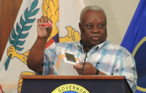 Gov. Kenneth Mapp demonstrates a solar light donated by the V.I. Humanitarian Relief Fund. (Jamie Leonard photo)