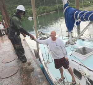 Officer Omari Lewis of the USVI Department of Planning and Environmental Resources shakes hands with Marc Weiser, after Weiser’s vessel was salvaged and returned Saturday. (U.S. Coast Guard photo)