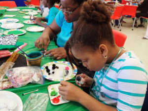 D’enoia Webbe, 7 works on a penguin ornament with her mother Carmen.