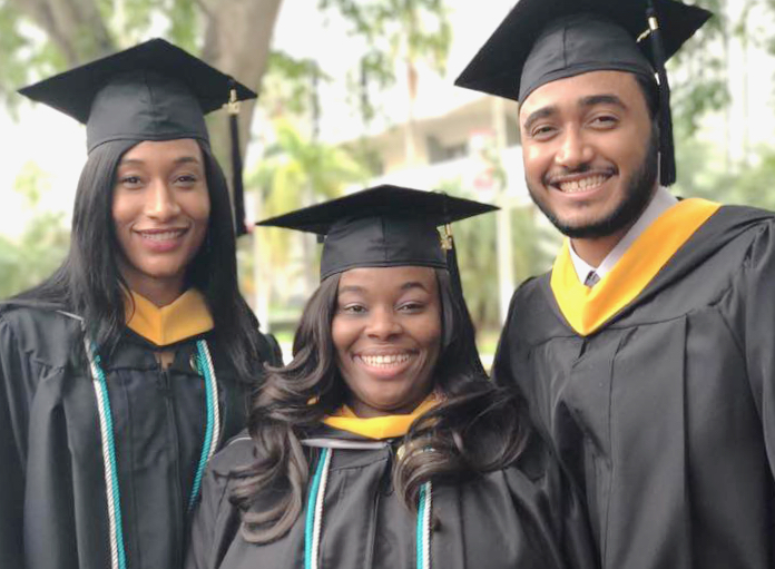From left, Camille Paul, Shenika Garner, and Anthony Centeno celebrate at Barry graduation ceremony in Miami.