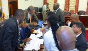 Sens. Marvin Blender, Kurt Vialet, Jean Forde, Novelle Francis, Nereida Rivera-O'Reilly, Kevin Smith, Janelle Sarauw, Sammuel Sanes and Dwayne Degraff huddle over budget documents during a recess of the Finance Committee Tuesday. (Barry Leerdam photo for the V.I. Legislature)