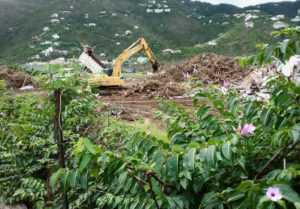 An earth mover sorts debris left by Hurricanes Irma and Maria on St. John.