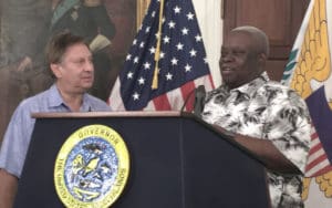 Jonathan Cohen accepts check on behalf of JKC Family from Gov. Kenneth Mapp at a Feb. 7 news conference. (Marina Leonard photo)