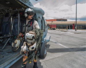 Naval Aircrewman 2nd Class Nicholas Glass carries flight gear back to an MH-60S Sea Hawk helicopter during humanitarian relief efforts in the wake of Hurricane Irma in September 2017. (U.S. Navy picture by Mass Communication Specialist 3rd Class Sean Galbreath/Released)