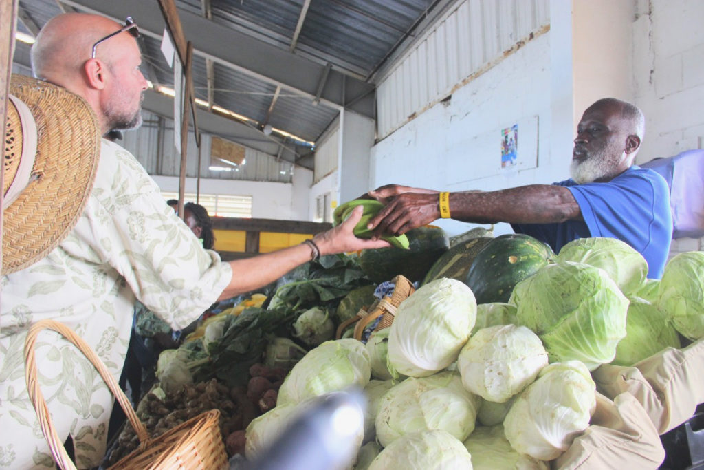 Dale Brown of Sejah Farms sells locally grown produce to a customer.