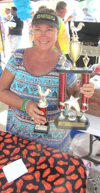 Kathy McAllister proudly displays the hardware won at previous competitions. The McAllister family enters yearly simply for 'they thrill of watching people enjoy Eric’s spices and rubs,' Kathy said.