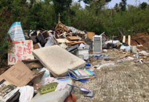 This bin site near Great Cruz Bay has become a dumping ground for all kinds of debris that does not belong there. An overturned sign reads, 'Stop dumping on the ground.'