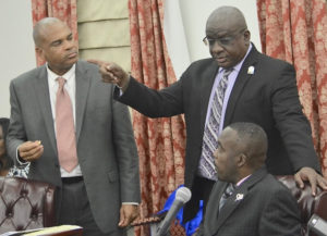 Sen. Marvin Blyden, seated, and Neville James, center, speak to Senator-at-large Brian Smith, who was absent during the zoning votes that allowed construction of a gas station on property he owns on St. John. (Photo by Barry Leerman for the V.I. Legislature)