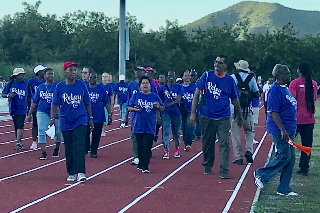 Cancer survivors, decked out in blue shirts, lead the opening march of the 17the annual Relay for Life on St. Croix.