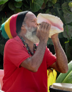 St. John culture bearer Delroy Anthony blows the conch shell as visitors arrive for the start of the 34th Fortsberg History Tour.