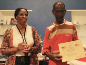 Delegate Stacey Plaskett presents Dennis McIntosh with the Purple Heart. (Image provided by Delegate Stacey Plaskett's office)