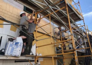 From left, William Cardis, Travis Haymaker, Gary Zbel, Jeff Dennison work on the historic Scale House. Elisa McKay photo)