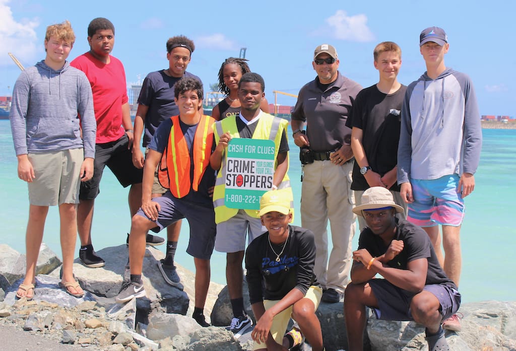 A team of students from Good Hope Country Day School joined with Crime Stoppers USV to post signs for the anonymous tip service. (VIPD photo)