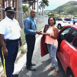 From left, STT Traffic Commander Lt. Lionel Bess and acting V.I. Police Commissioner Jason Marsh reward an anonymous female motorist. (VIPD photo)