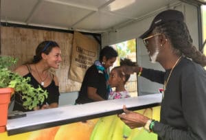 Positive Nelson steps up to the counter of a farm tienda staffed by Shelli Brin Olive, Nicole Schuster and her daughter. (Elisa McKay photo)