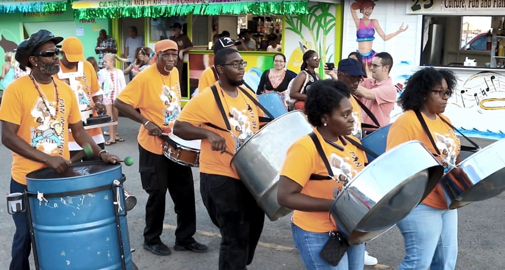 Pan in Motion led a procession from booth to booth Friday night, paying tribute to honoree Michael Coggins.