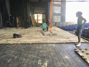 Workmen apply new plywood flooring on top of the old wooden floor. (Eliza McKay photo)