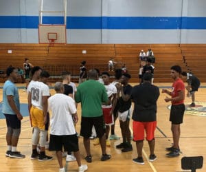 Coach Jareem Dowling, back to the camera in the green shirt, talks to the team at practice. (Submitted photo)