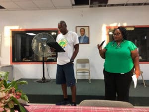 Elroy Hill of Sports, Parks and Recreation checks his notes while CDBG program manager Tamish Thomas records his presentation during a public meeting at Cruz Bay. (Source photo by Amy Roberts)