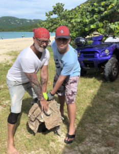 The father and son team of Alexey and Mikhail Dubovoy haul a big chunk of construction waste off Brewers Bay. (Source photo by Teddi Davis)