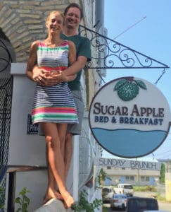 Corina Marks and Ryan Flegal, new owners of the Sugar Apple Bed and Breakfast pose with the new sign. (Source photo by Susan Ellis)