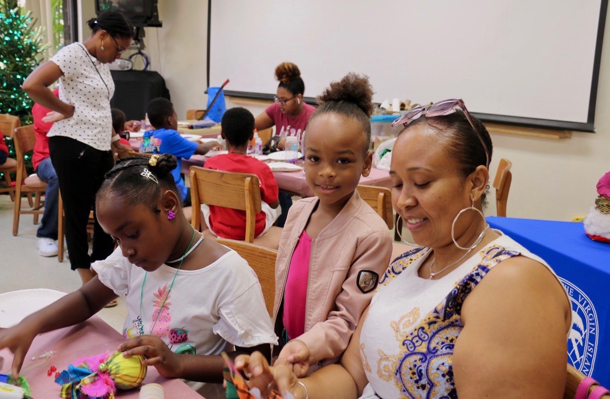 Ashayla Coates concentrates (left) on her creation while Denae Jenicins stands next to her mother, Cassandra King to collaborate on Christmas decor. (Source photo by Linda Morland)