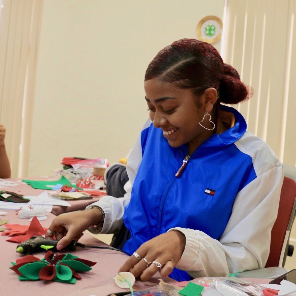 4-H Ambassador, Justice Veira, one of 15 Ambassadors assisting at the event, enjoys the opportunity to help younger children prepare for Christmas. (Source photo by Linda Morland)