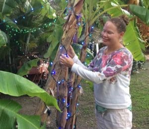 Volunteer Lise Sorensen with one of the many trees and bushes decorated on the grounds. (Source photo by Don Buchanan)