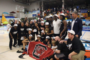 Gov. Albert Bryan, in the white shirt, poses with Aliyah Boston and the University of South Carolina women's team as they receive the Reef Division Trophy. (Photo by Basketball Travelers)