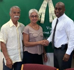 From left, J.T. Torres and Angela Morales are congratulated by VIHFA director Daryl Griffith. (Photo provide by VIHFA)