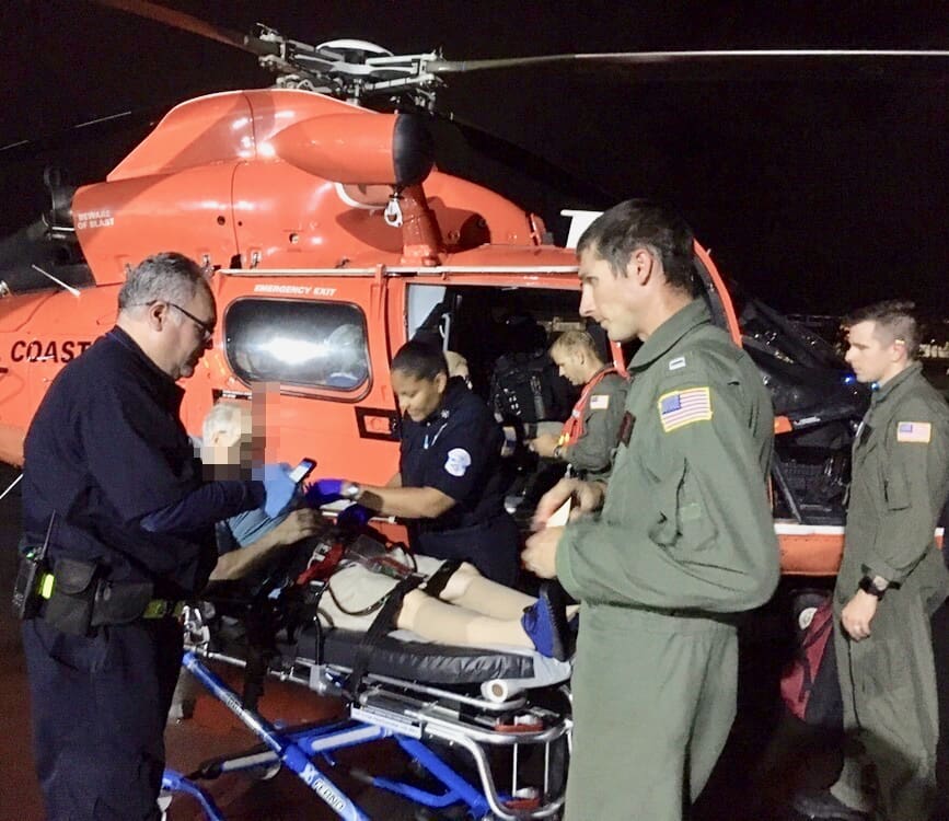 The crew of a Coast Guard MH-65 Dolphin helicopter from Air Station Borinquen transfers a 68-year-old man to emergency medical service personnel at the airport in San Juan, Puerto Rico. The man is a U.S. citizen who was a passenger aboard the Queen Mary 2 and was medically evacuated. (U.S. Coast Guard photo)