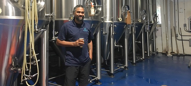 Nico Cherubin, sale and distribution manager of Leatherback Brewery, has a beer among the vats. (Source photo Susan Ellis).