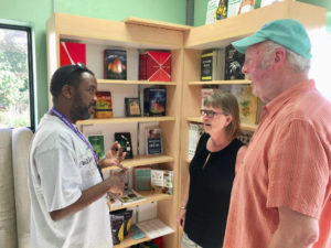 Magabe Calixte discusses products with Paula and Greg Hachmeister. (Source photo by Amy Roberts)