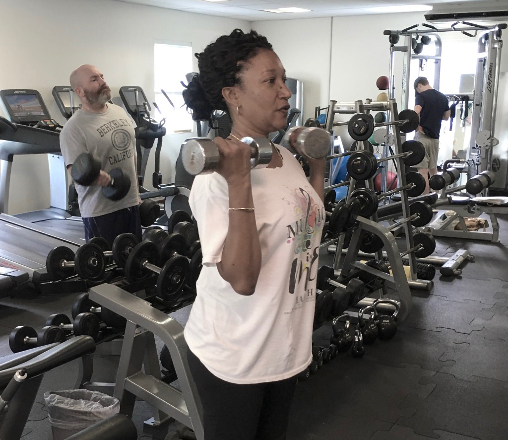 STJ Resident Miriam Sorhaindo-Otto and visitor Chuck McCall (seen behind Sorhaindo-Otto) lift weights. (Source photos by Amy Roberts)