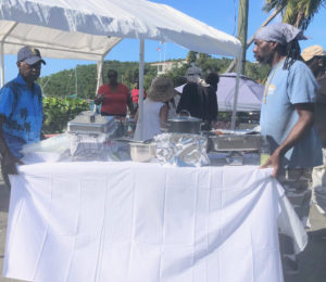 Alvis Christian from Johns Folly Learning Institute and promoter Roy Reid maneuver a table into the serving station. (Source photo Judi Shimel)